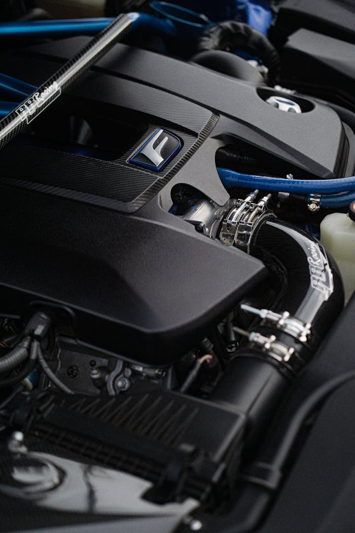 Detailed view of a car engine with blue accents emphasizing mechanical components.